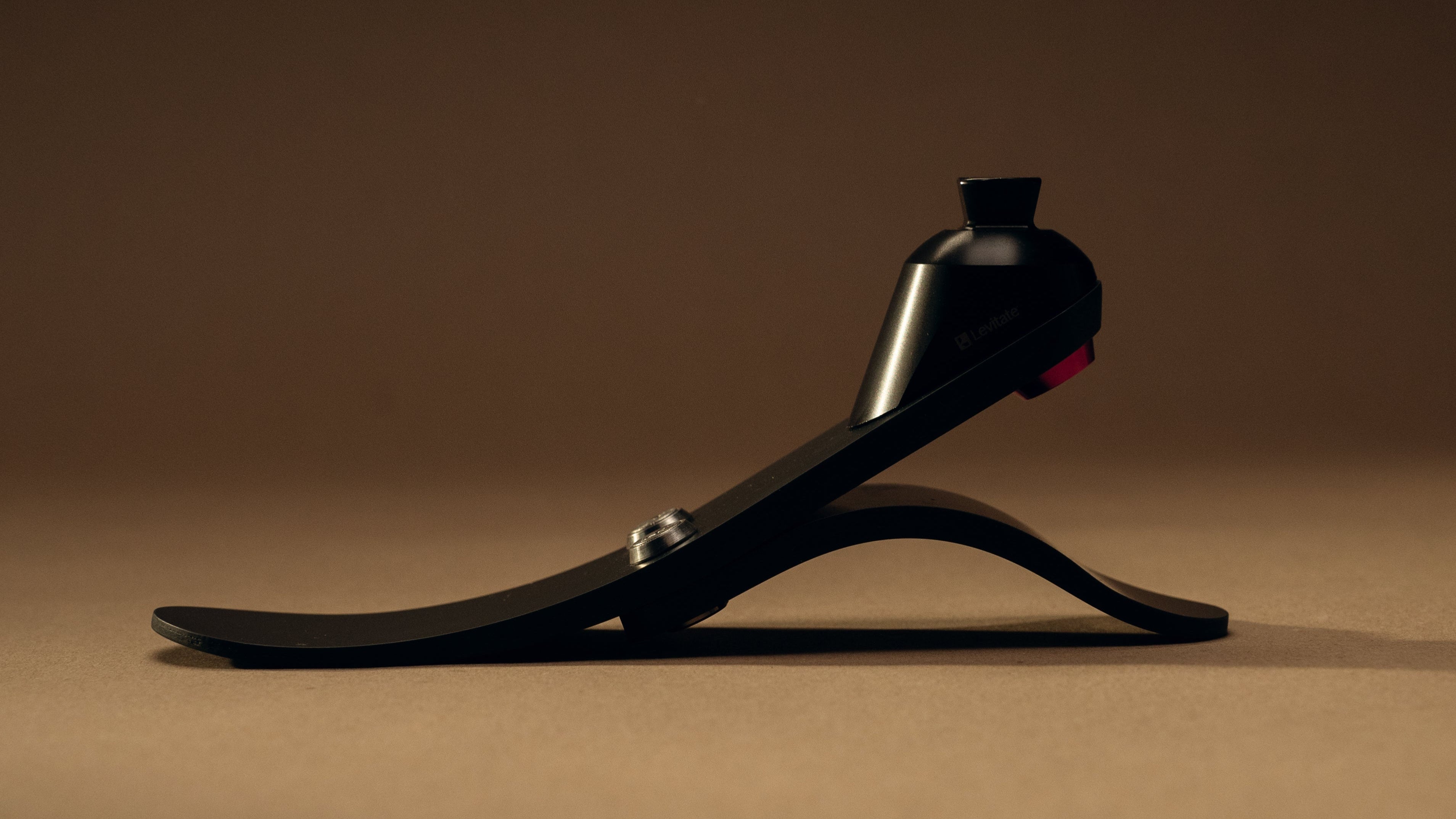 Black prosthetic foot on a brown background