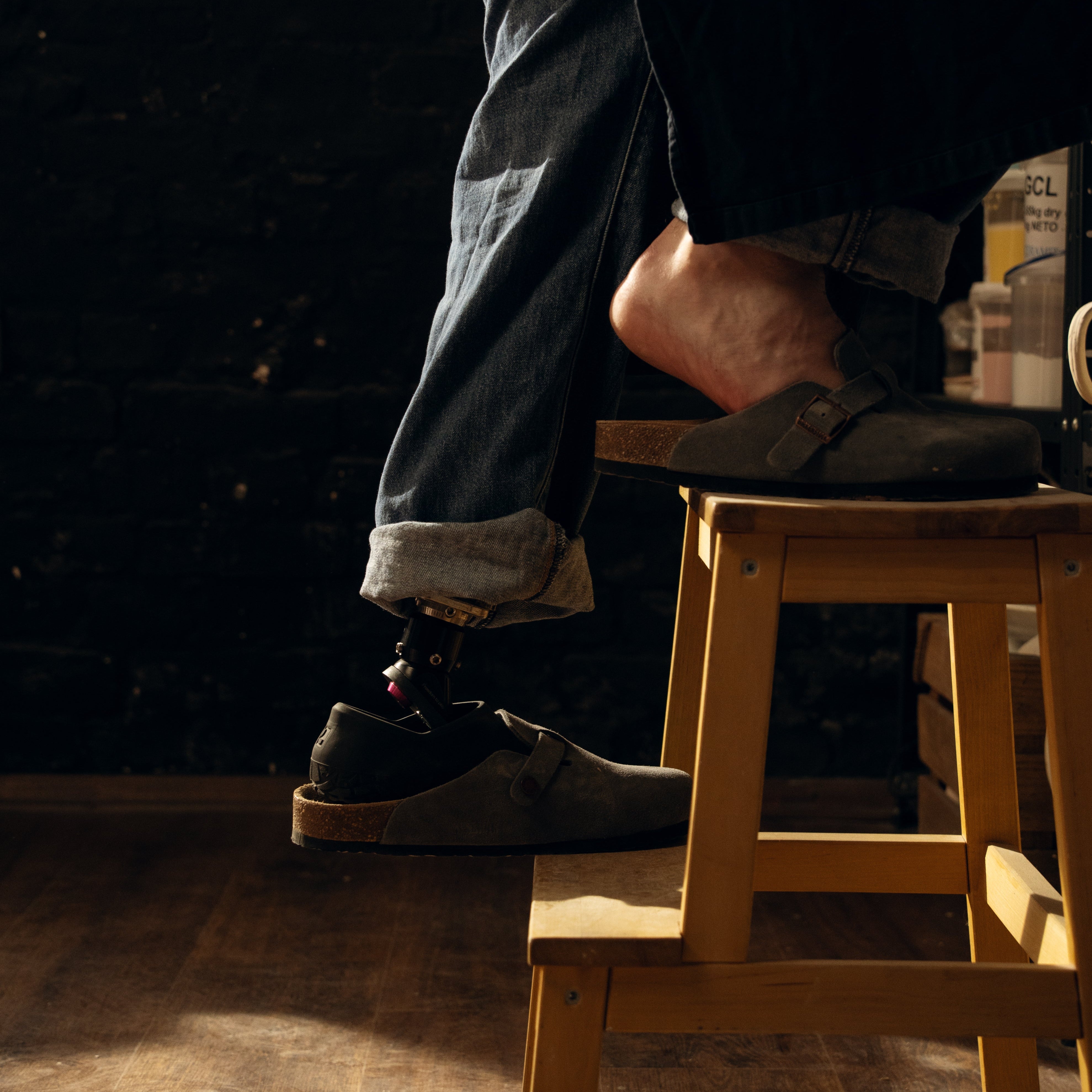 Prosthetic foot om a wooden stool with a dark background