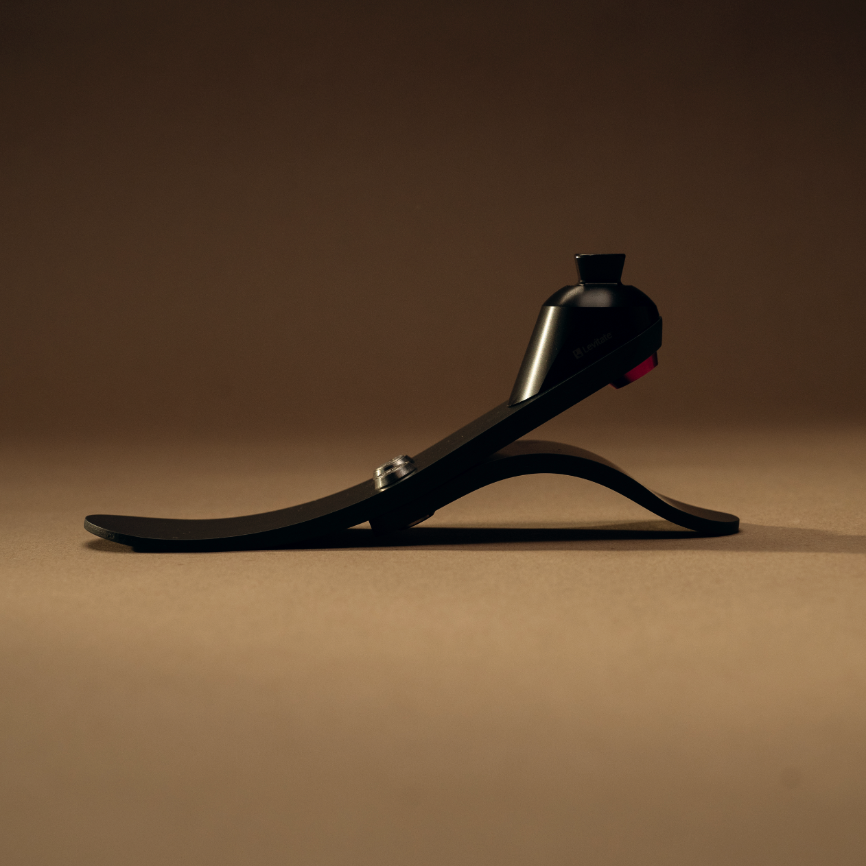 Low profile prosthetic foot on a brown background